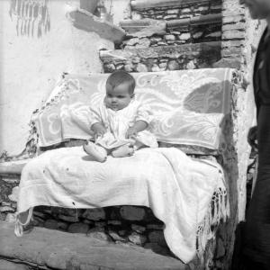Melissa (Crotone) - Neonato seduto su asciugamani sulla scala esterna di una casa - Ritratto
