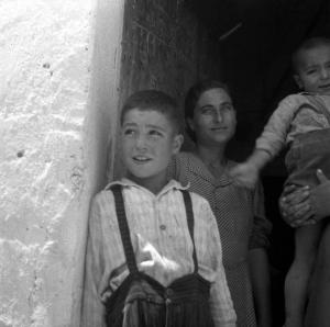 Melissa (Crotone) - Donna con bambini sull'uscio di una casa