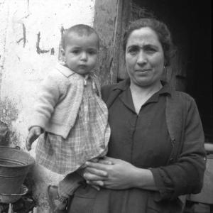 Melissa (Crotone) - Donna con bambino in braccio sull'uscio di una casa - Ritratto