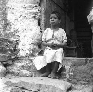 Melissa (Crotone) - Bambino seduto sull'uscio di una casa