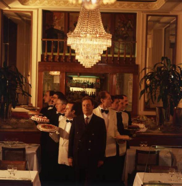 Ritratto maschile - adulto - Alfio Bocciardi circondato da camerieri con piatti di portata - Savini