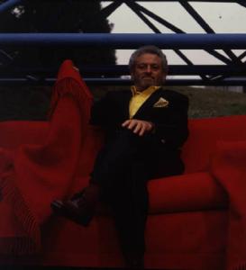 Ritratto maschile - adulto - Pierino Busnelli su un divano rosso - industriale - B & B Italia - mobili