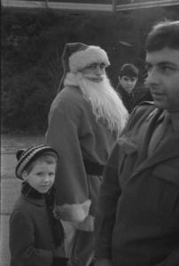 Piero d'Alfonso vestito da Babbo Natale con un bambino e un militare al Luna Park delle Varesine