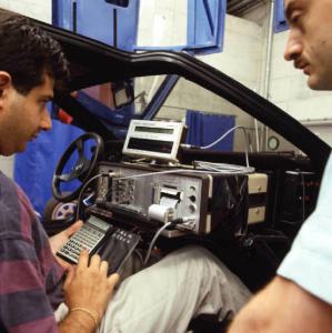 Coppia di uomini esegue un test ad apparecchiature a bordo di un'automobile