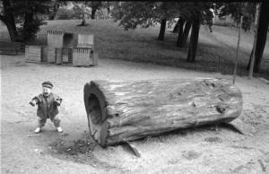 Bambino e tronco cavo al parco giochi