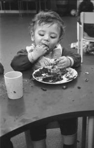 Bambino dell'asilo mangia con le mani