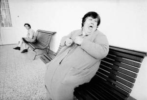 Ritratto femminile - adulta ospite di un ospedale psichiatrico seduta su di una panca
