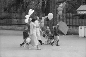 Mamme con bambini e palloncini passeggiano nel parco