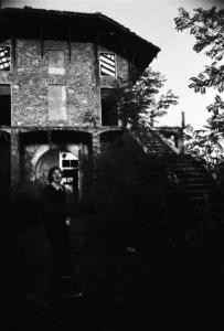 Giovane uomo davanti a una casa abbandonata