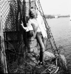Carola appoggiata a una rete sulle rive di un lago