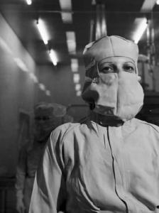 Glaxo - Ritratto di un ricercatore in camice bianco e mascherina in un laboratorio - sullo sfondo un altro medico