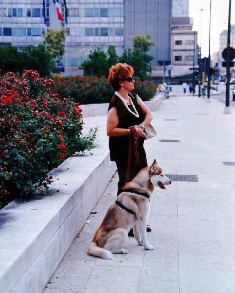 Milano - Centro urbano - Piazza Duca d'Aosta - Marciapiede - Ritratto femminile: donna con un cane