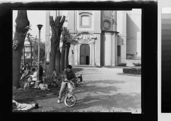 Trucazzano - piazza Maiolo - gruppo di persone nel giardino antistante la chiesa parrocchiale