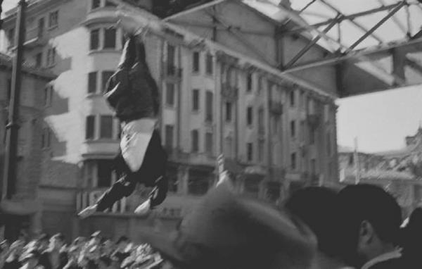 Seconda guerra mondiale. Resistenza italiana. Liberazione di Milano. 29 aprile 1945. Il corpo di Benito Mussolini esposto alla folla in piazzale Loreto appeso alle travi della tettoia del distributore di benzina Esso.