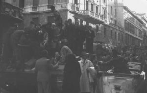 Seconda guerra mondiale. Liberazione di Milano. 29 aprile 1945. Corso Monforte nei pressi del Palazzo del Governo sede della Prefettura, colonna di carri armati Sherman dell'esercito americano sommersi dalla folla in festa.