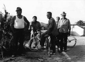 Gente di paese a piedi e in bicicletta - campo di granoturco