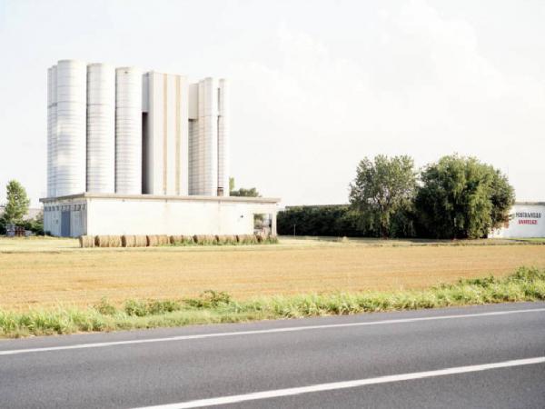 Fabbrica con silos - campo tagliato - balle di paglia - strada