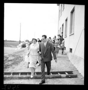 Matrimonio - Coppia di sposi in cammino lungo il perimetro di una casa popolare - Corteo nuziale - Mantova - Quartiere Te Brunetti