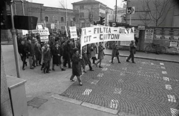 Corteo dei lavoratori tessili in sciopero: operai della Cantoni con striscione, cartelli e fischietti
