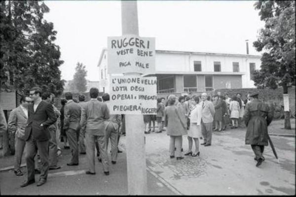 Sciopero dei dipendenti della Ruggeri (Unimac): i lavoratori si sono radunati all'esterno dei cancelli della fabbrica. In primo piano due cartelli di protesta che inneggiano all'unità fra operai e impiegati