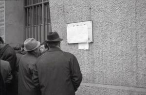 Sciopero dei lavoratori ENEL: due uomini leggono i documenti affissi fuori dalla sede di via Procaccini a Milano