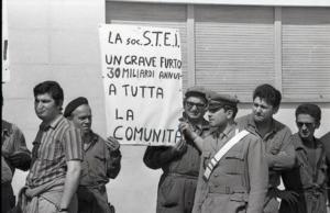 Sciopero alla STEI di Tavazzano: due lavoratori mostrano un cartello con la scritta "La soc. S.T.E.I. / un grave furto / 30 miliardi annui a tutta la comunità"
