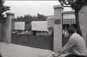 Occupazione della Confezioni Galimberti: le operaie, asserragliate dietro i cancelli dell'ingresso dello stabilimento, mostrano striscioni e cartelli con la scritta "Fabbrica occupata"