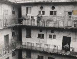 Milano -  Quartiere Stadera - Casa di ringhiera - Ballatoi - Una donna stende la biancheria