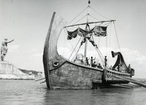 Scena del film "Fabiola" - Regia Alessandro Blasetti, 1949 - Su un'imbarcazione in legno: alcuni attori non identificati spiegano le vele. A sinistra una statua di uomo con il braccio teso.
