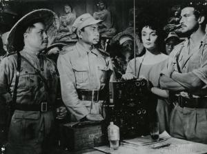 Scena del film "La figlia di Mata Hari" - Merusi, Renzo, 1954 - Ludmilla Tcherina, al centro appoggiata a una radio, guarda davanti a sé. Intanto, Erno Crisa, a destra, e Valéry Inkijinoff, a sinistra, si osservano.
