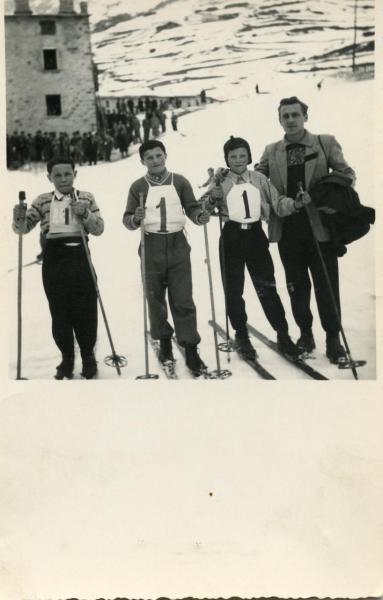 Adulto e tre bambini sugli sci