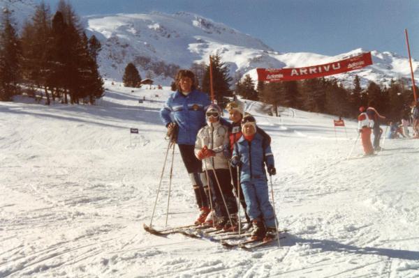 Maestro di sci con allievi al traguardo