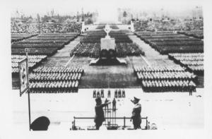 Nazismo - Germania - Raduno del Fronte del lavoro - Lavoratori schierati con torso nudo e pala - Adolf Hitler con un capo di lavoratori - Saluto nazista - Croce uncinata (svastica)