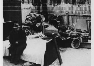 Nazismo - Ungheria, Budapest (o Polonia?) - Cortile - Uomo ebreo sfrattato seduto su un letto - Mobilia in cortile - Antisemitismo