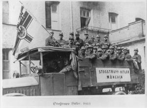 Germania, Monaco - Foto di gruppo: Stoßtrupp di Adolf Hitler, uomini in divisa del reparto di protezione in posa su camionetta - Bandiera imperiale - Fascia con croce uncinata / svastica - Nazismo