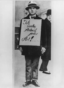 Germania, Berlino - La Grande Depressione / Grande crisi - Ritratto maschile: uomo disoccupato con un cartello "Ich suche Arbeit jeder Art!..." (cerco lavoro di qualsiasi tipo!)