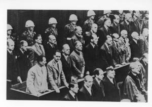 Dopoguerra - Germania, Norimberga - Processo ai principali criminali di guerra, i capi nazisti - Tribunale internazionale, interno - Panche con imputati - Polizia in divisa / Tra gli imputati: fila posteriore: K. Dönitz, E. Raeder, B. von Schirach, F. Sauckel, A. Jodl, F. von Papen, A. Seyß-Inquart, A. Speer, K. von Neurath, H. Fritsche / Tra gli imputati: fila anteriore: H. Göring, R. W. R. Hess, J. von Ribbentrop, W. Keitel, E. Kaltenbrunner, A. Rosenberg, H. Frank, W. Frick, J. Streicher