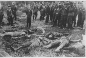 Seconda guerra mondiale - Nazismo - Ucraina - Occupazione tedesca - Eccidio di ebrei - Fucilazione / esecuzione - Ragazzo davanti ai cadaveri dei suoi famigliari assassinati - SS della polizia ausiliaria ucraina in divisa