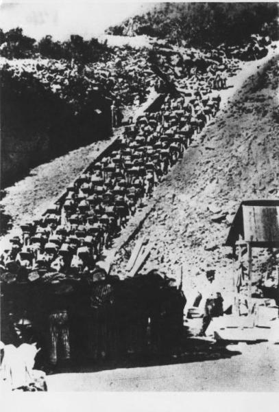 Seconda guerra mondiale - Nazismo - Austria - Campo di concentramento di Mauthausen-Gusen - "Scala della morte" dal campo verso la cava di pietra - Kommando di prigionieri con pigiama a strisce ("zebrati") trasportano pietre - Lavori forzati