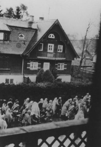Seconda guerra mondiale - Nazismo - Germania - Marcia di evacuazione dei prigionieri (marcia della morte) dal campo di concentramento di Dachau a Bad Toelz - Fotografia dall'alto - Donne in cammino con coperte sulla testa - Strada cittadina - Casa