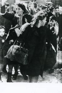 Seconda guerra mondiale - Polonia, Varsavia - Ghetto ebraico - Repressione della rivolta della popolazione ebraica - Arresto di massa di ebrei - Donne e bambini con mani alzate - Antisemitismo - Nazismo / Tra gli ebrei arrestati: Hanka Lamet (la bambina a sx); Matylda Lamet Goldfinger (la madre, la seconda a sx); Leo Kartuzinsky (il ragazzo in fondo con la sacca ); Chana Zeilinwarger (la donna davanti)