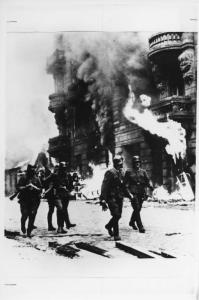Seconda guerra mondiale - Polonia, Varsavia - Ghetto ebraico - Repressione della rivolta della popolazione ebraica - Strada - Truppa SS in divisa - Palazzo in fiamme - Nazismo