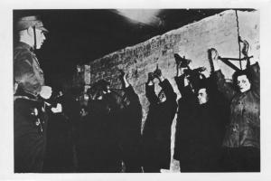 Nazismo - Germania, Berlino - Locale del Sturmabteilung SA (reparto d'assalto), interno - Oppositori comunisti ammanettati al muro con mani alzate - Sturmabteilung SA in divisa con fucile - Tortura