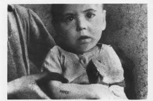Nazismo - Polonia - Ritratto infantile: bambino ebreo (?) con il numero di matricola 25171 tatuato sul braccio