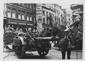 Nazismo - Occupazione della Renania - Germania, Colonia - Ingresso delle truppe tedesche in città - Marcia della Wehrmacht (forze armate tedesche) con soldati in divisa su cannone - Artiglieria, cannone