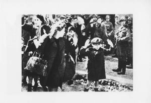 Seconda guerra mondiale - Polonia, Varsavia - Ghetto ebraico - Repressione della rivolta della popolazione ebraica - Arresto di massa di ebrei - Donne e bambini con mani alzate - SS in divisa (sulla dx Josef Blösche) - Antisemitismo - Nazismo / Tra gli ebrei arrestati: Hanka Lamet (la bambina a sx); Matylda Lamet Goldfinger (la madre, la seconda a sx); Leo Kartuzinsky (il ragazzo in fondo con la sacca ); Chana Zeilinwarger (la donna davanti)