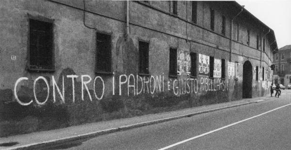 Scritte murali. Sesto San Giovanni (?) - Muro di un edificio - Scritta murale - Manifesti - Passanti