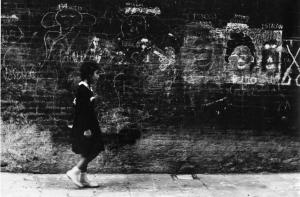 Scritte murali. Venezia - Muro con graffiti e disegni - Bambina con grembiule di scuola