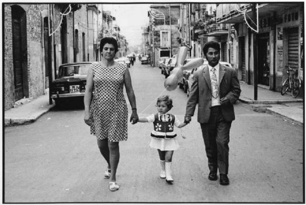 Abruzzo, Luco dei Marsi - Strada - Ritratto di famiglia - Uomo, donna con bambina con palloncino - Abito da festa