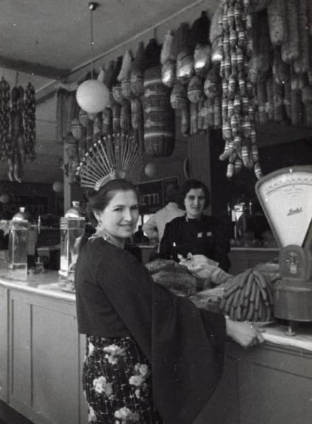 Fiera di Milano - Campionaria 1937 - Donna in costume ad un chiosco di alimentari